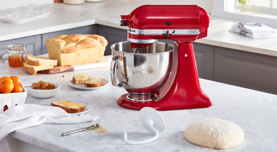 Red KitchenAid® Stand Mixer on countertop next to a baked loaf of bread, dough hook accessory and ball of dough  Red KitchenAid® Stand Mixer on countertop next to a baked loaf of bread, dough hook accessory and ball of dough