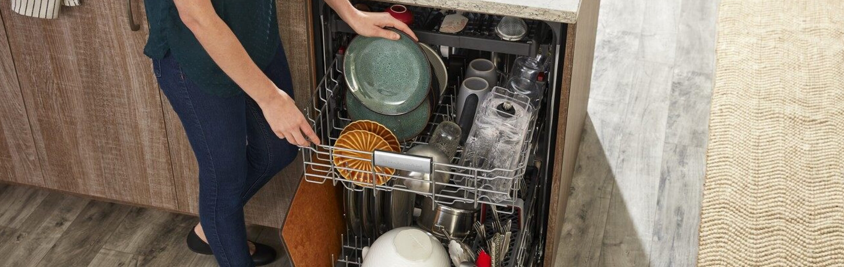 Person loading dishes into dishwasher