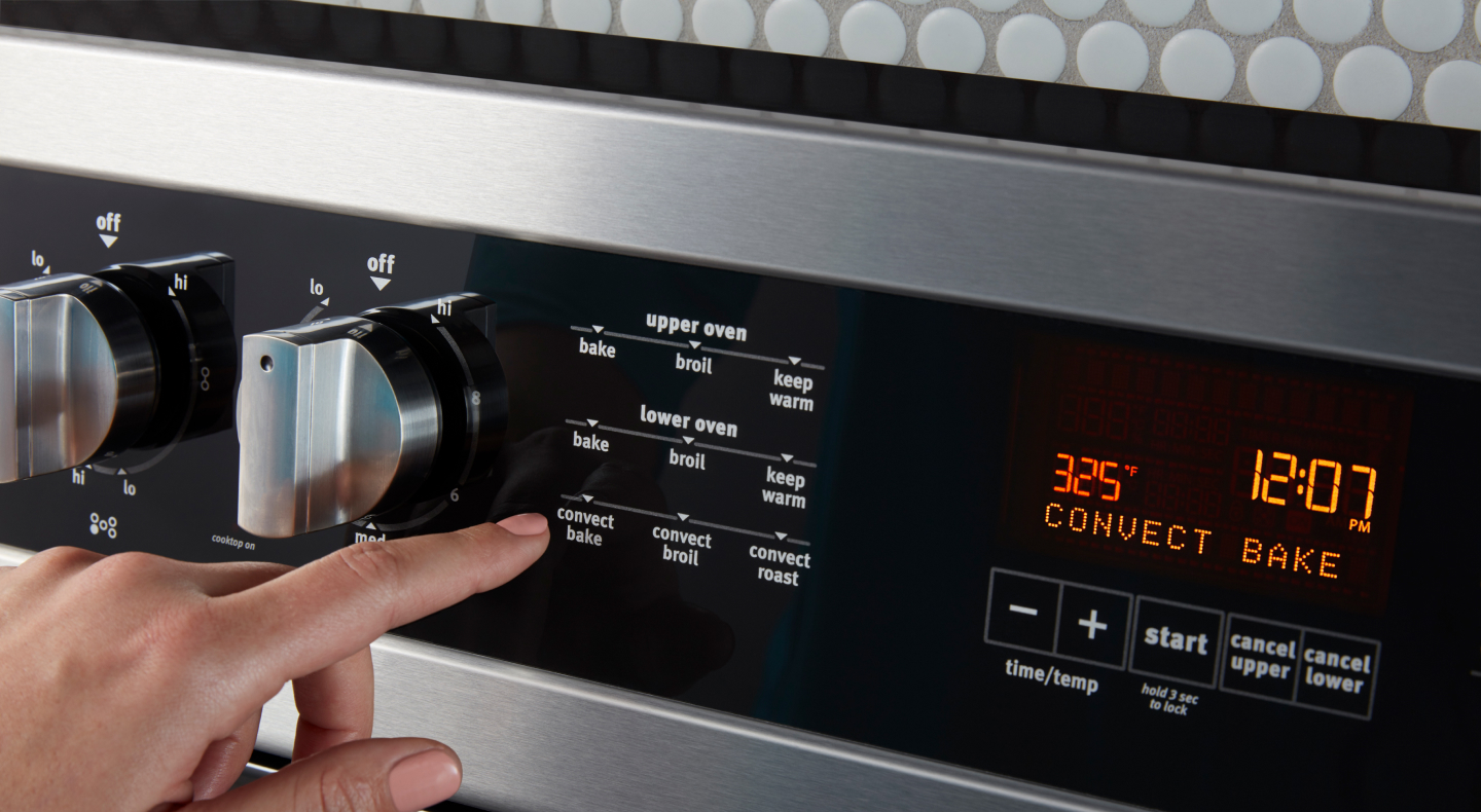 Person pressing buttons on a range Person pressing buttons on a range