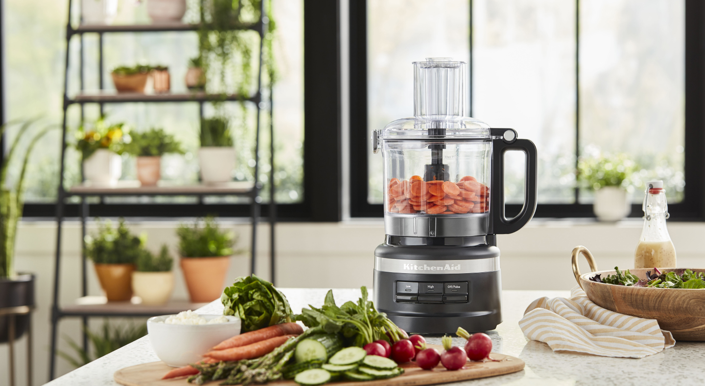 A food processor and cutting board with charcuterie ingredients A food processor and cutting board with charcuterie ingredients