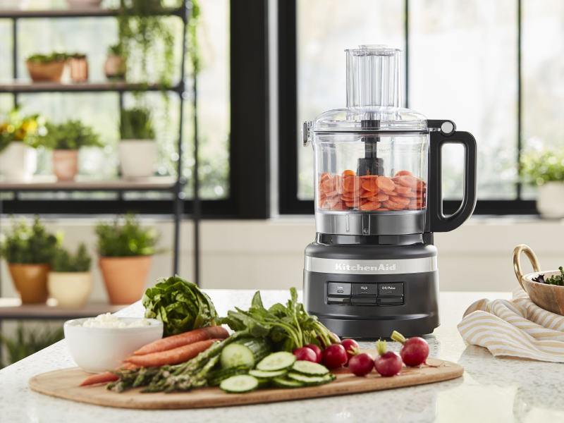 A food processor and cutting board with charcuterie ingredients A food processor and cutting board with charcuterie ingredients