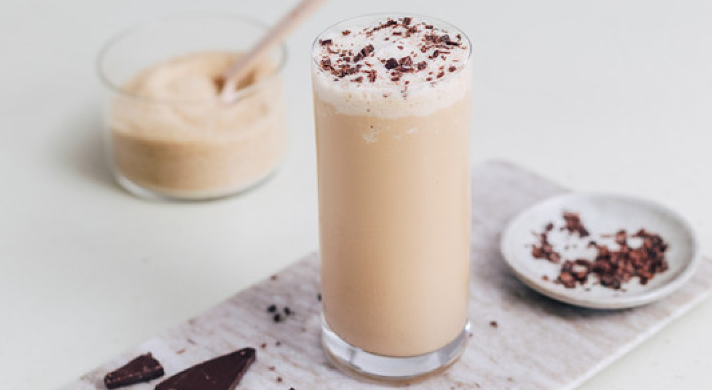 Frappe in a tall glass topped with fresh chocolate shavings