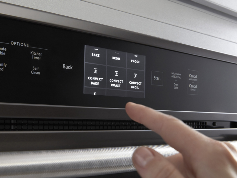 Person selecting a bake setting on a KitchenAid® oven