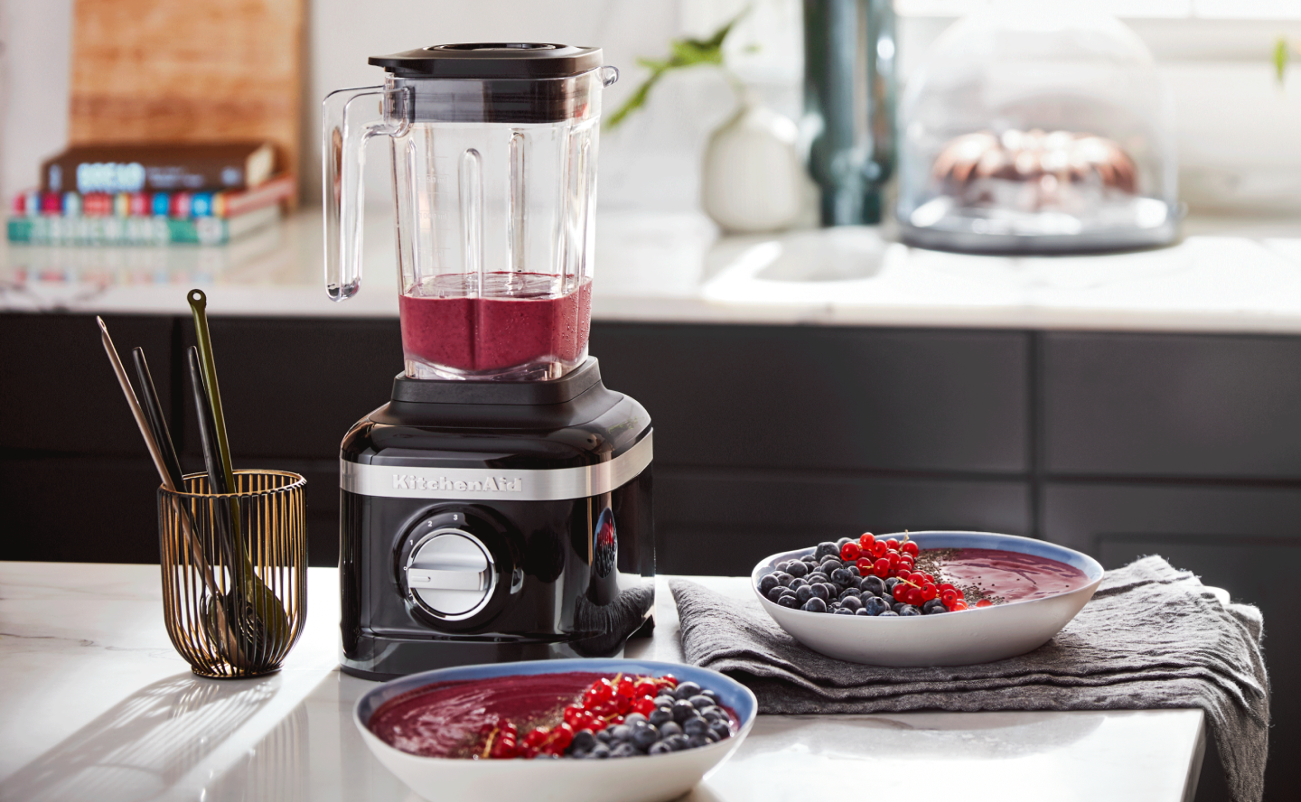 Black KitchenAid® blender next to two acai bowls