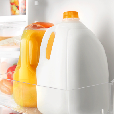 Milk and orange juice inside a refrigerator