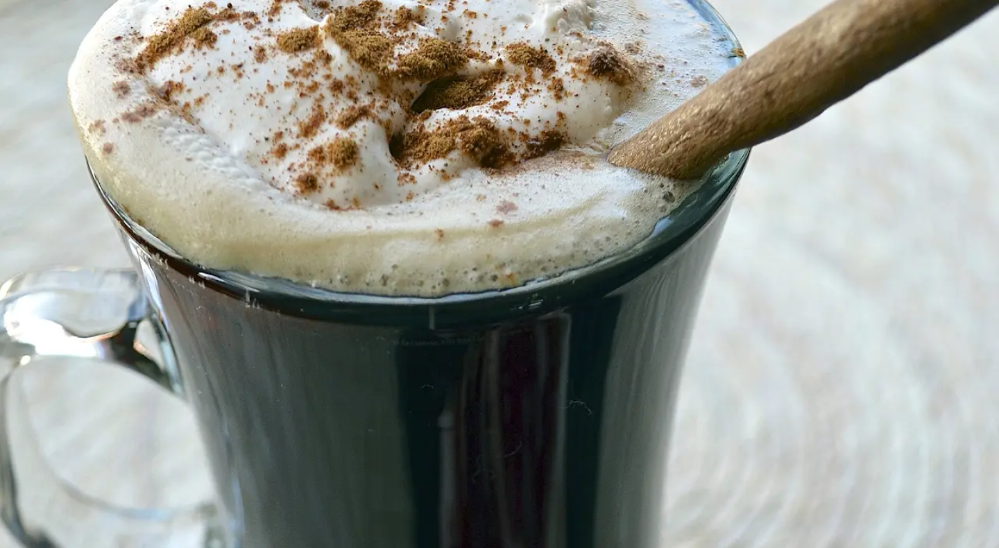 Hot Irish coffee topped with whipped cream and cinnamon Hot Irish coffee topped with whipped cream and cinnamon