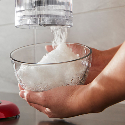 Person using a KitchenAid® stand mixer with shave ice attachment