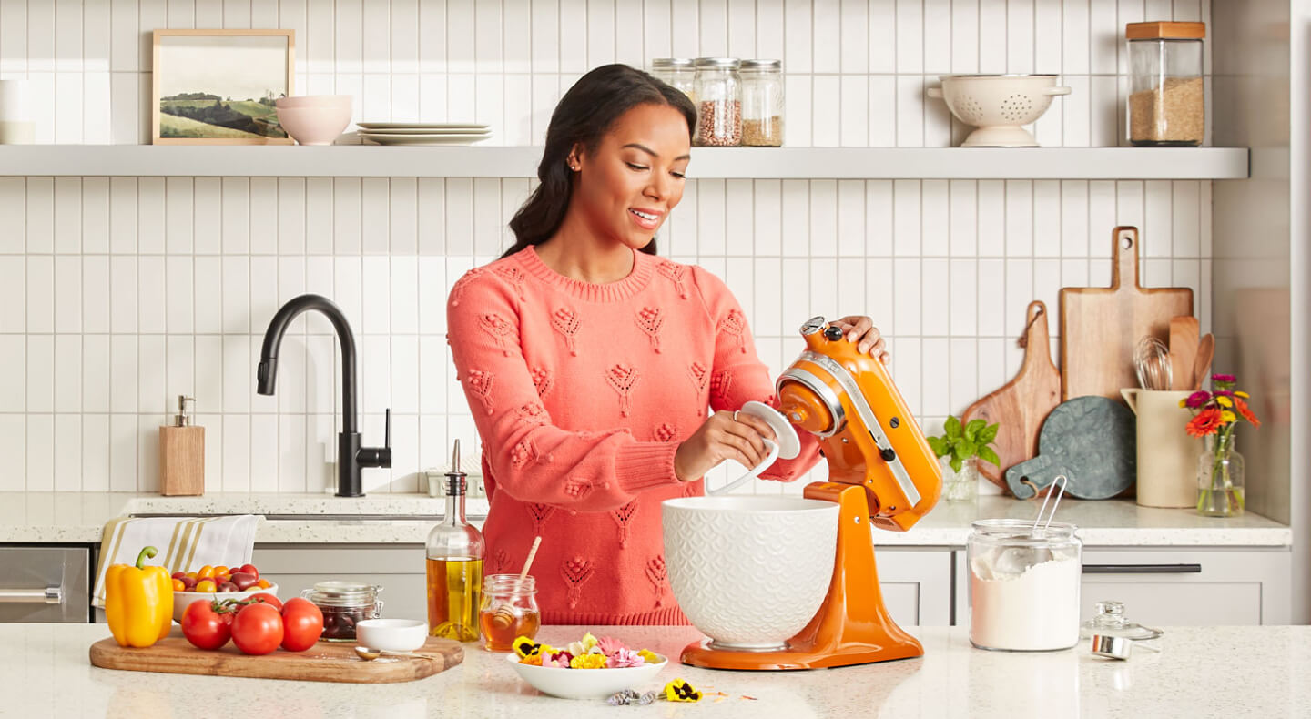 Person attaching the KitchenAid® Dough Hook accessory to an orange stand mixer Person attaching the KitchenAid® Dough Hook accessory to an orange stand mixer