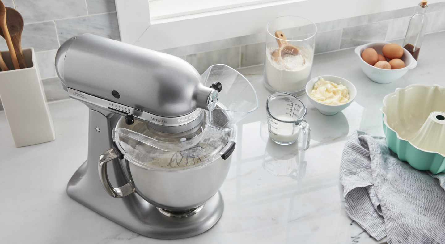 Stainless steel stand mixer next to to cake batter ingredients Stainless steel stand mixer next to to cake batter ingredients