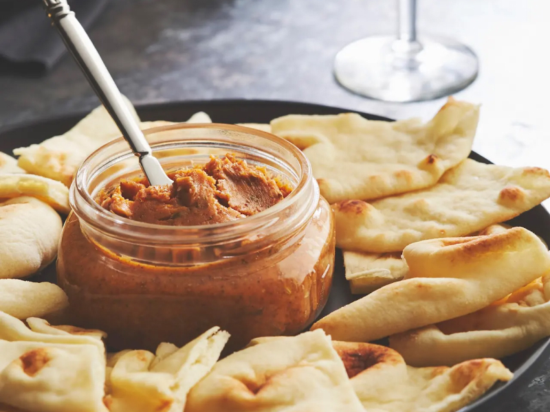 Jar of butter with pita triangles around it