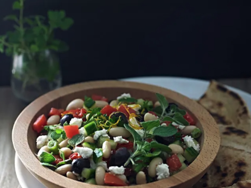 A closeup of a Mediterranean white bean salad.