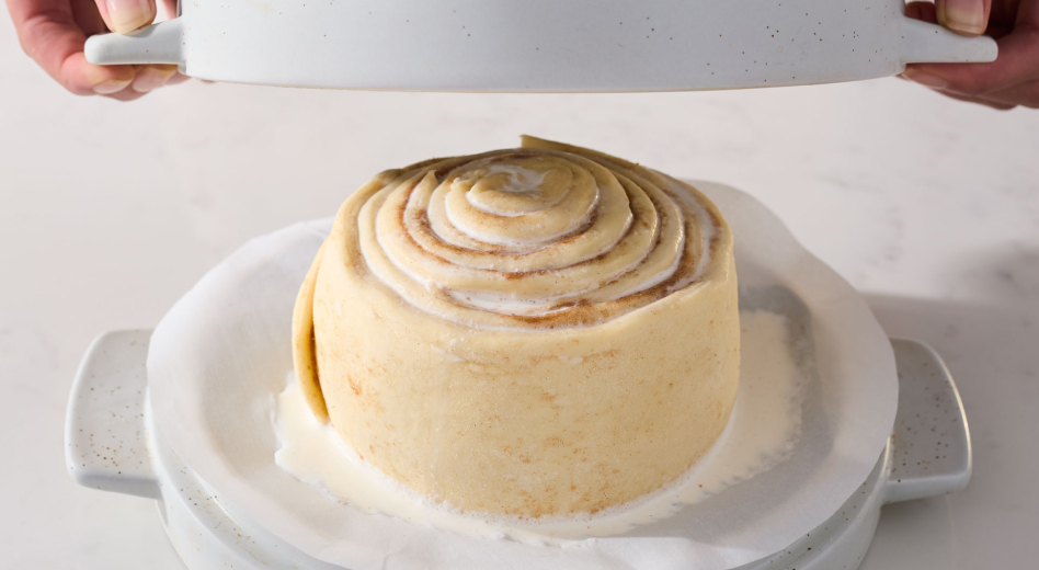 Person covering cinnamon roll bread dough to bake Person covering cinnamon roll bread dough to bake