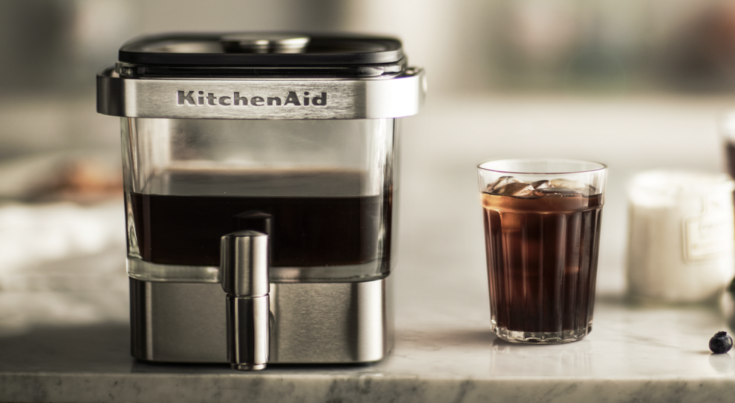 KitchenAid® cold brew coffee maker next to a glass