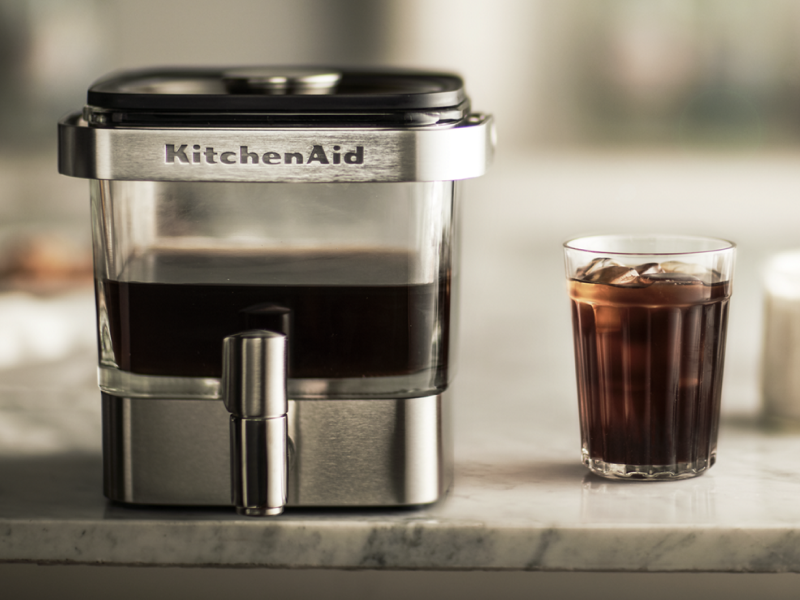 KitchenAid® cold brew coffee maker next to a glass KitchenAid® cold brew coffee maker next to a glass