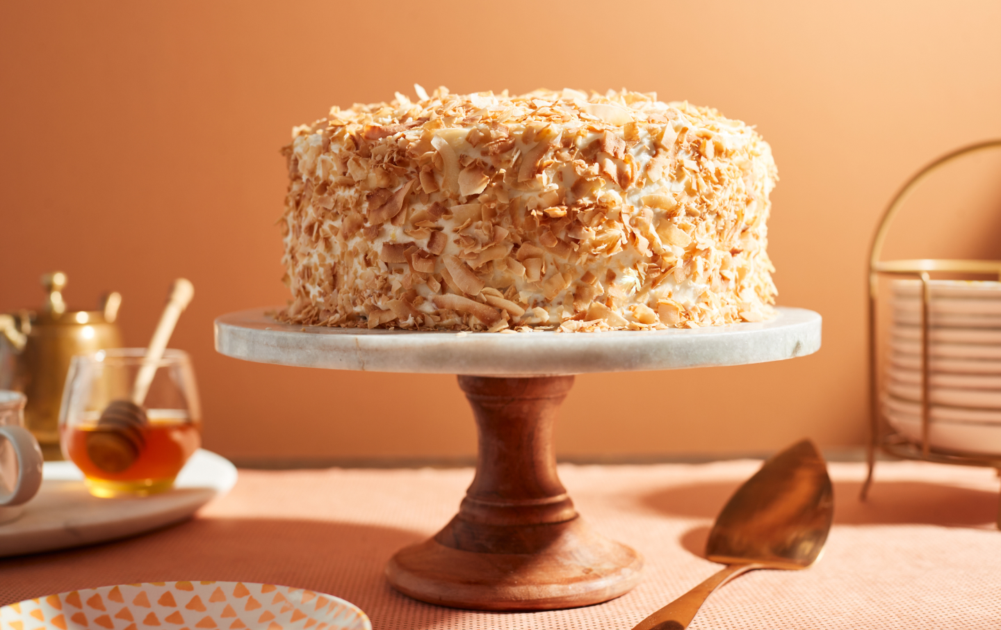 Cake covered in toasted coconut flakes on a cake stand Cake covered in toasted coconut flakes on a cake stand