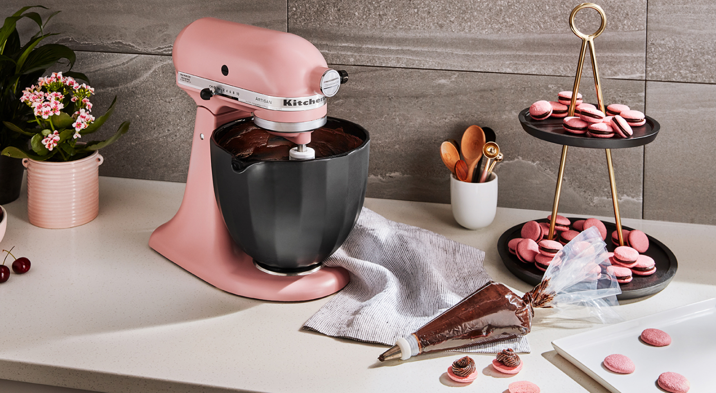 KitchenAid® stand mixer next to piping bag with chocolate buttercream frosting and macaroons KitchenAid® stand mixer next to piping bag with chocolate buttercream frosting and macaroons
