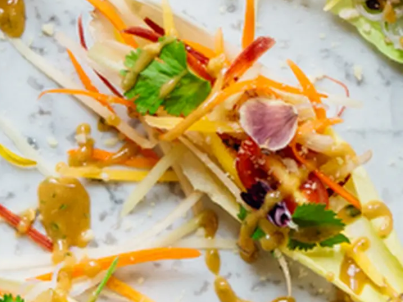 Appetizers topped with shredded vegetables and fresh herbs