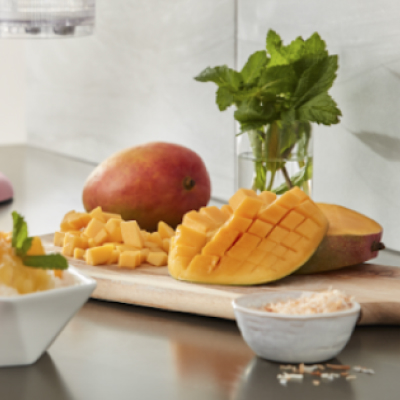Sliced mangoes and herbs on a cutting board