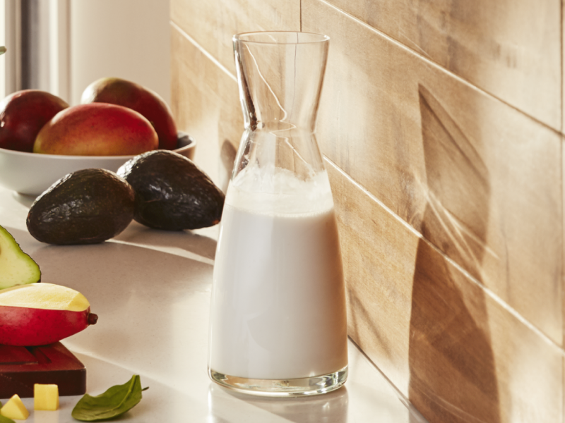 Small pitcher of milk on counter with fresh ingredients