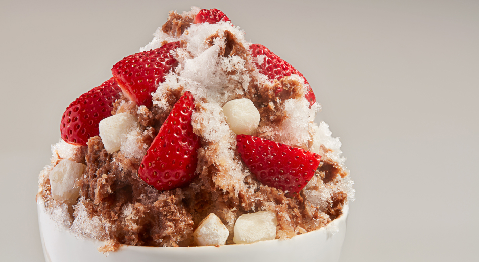 A cup of kakigori topped with strawberry chunks. A cup of kakigori topped with strawberry chunks.