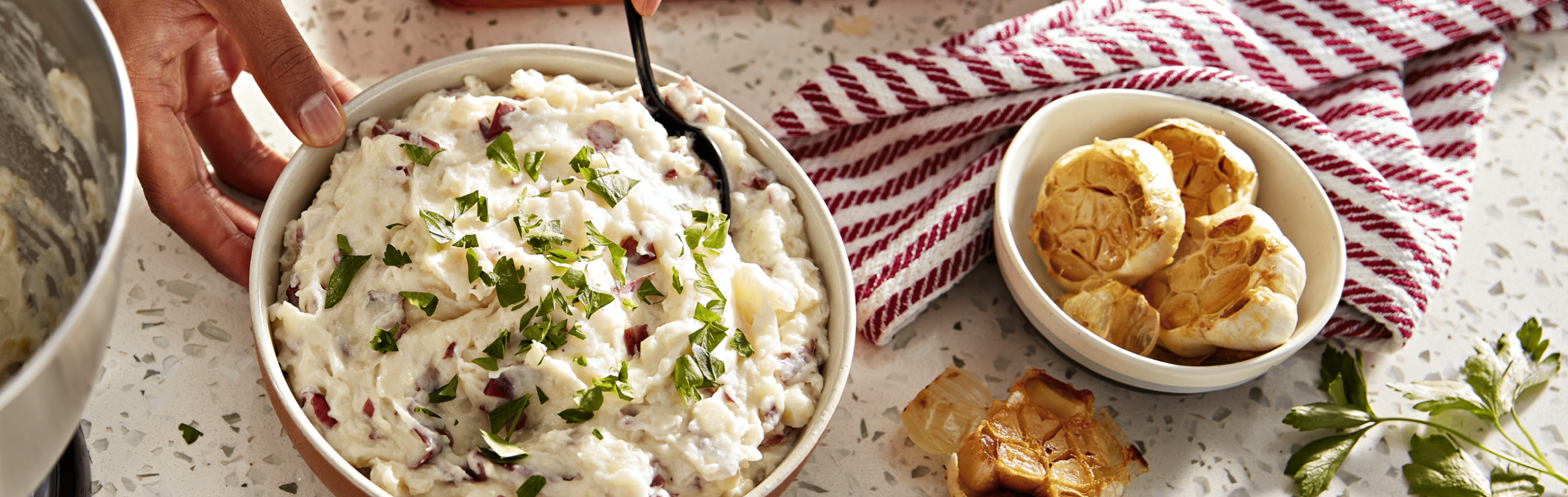 Bowls of red-skinned mashed potatoes and roasted garlic