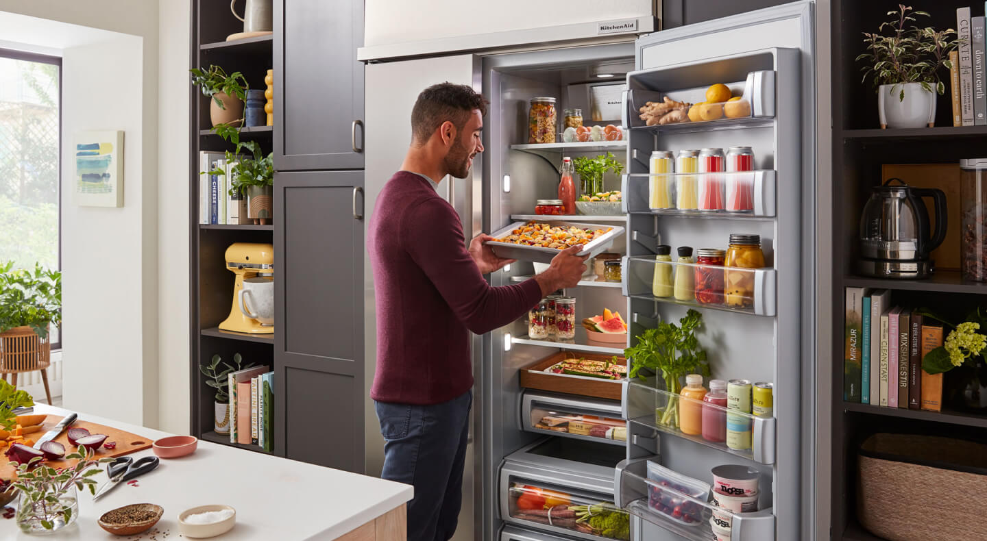 Man pulling sheet of fresh pasta from refrigerator Man pulling sheet of fresh pasta from refrigerator