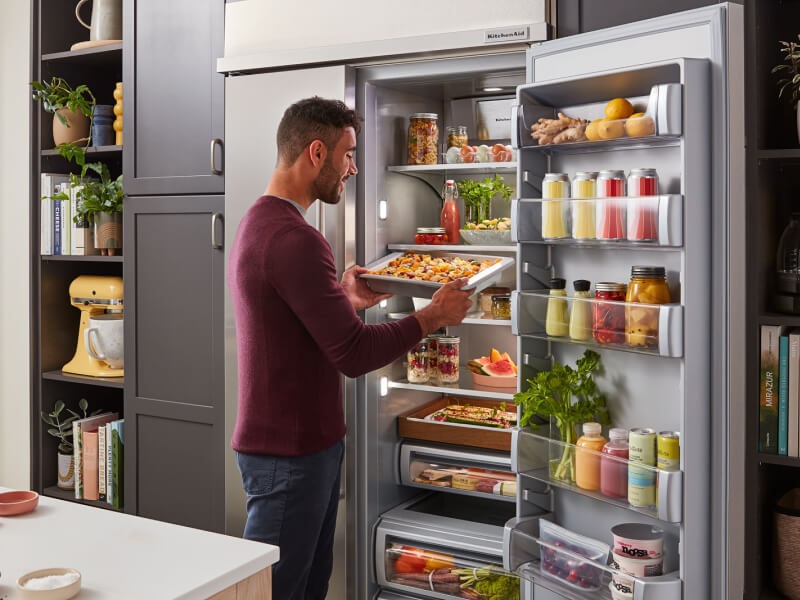 Man pulling sheet of fresh pasta from refrigerator Man pulling sheet of fresh pasta from refrigerator