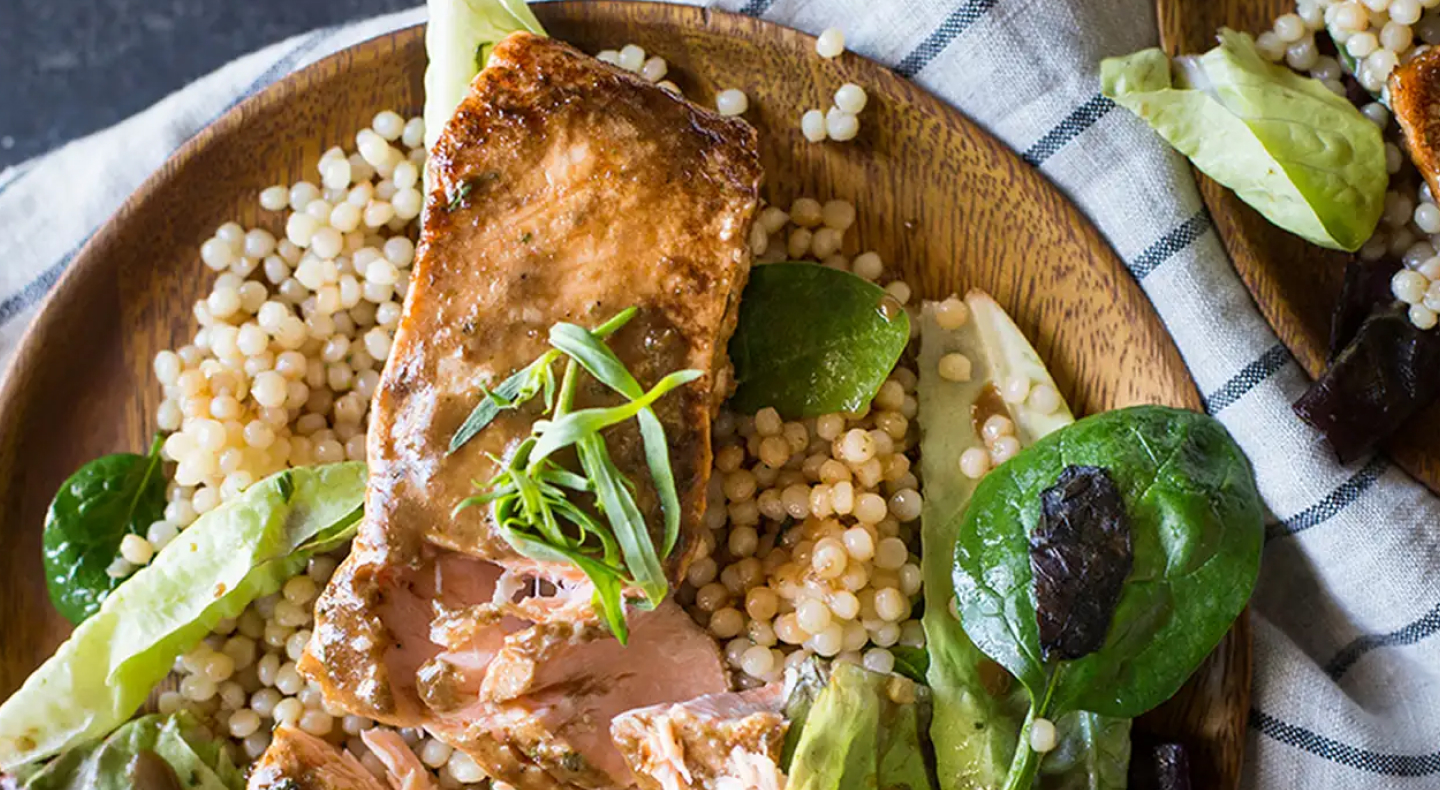 Salmon, couscous and greens on dinner plate Salmon, couscous and greens on dinner plate