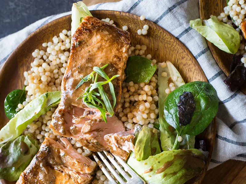 Salmon, couscous and greens on dinner plate Salmon, couscous and greens on dinner plate