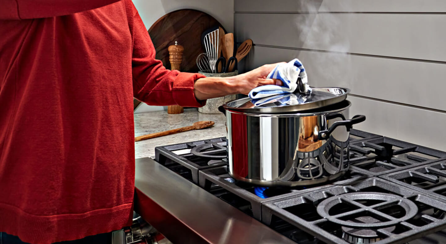 Person putting lid on a pot Person putting lid on a pot