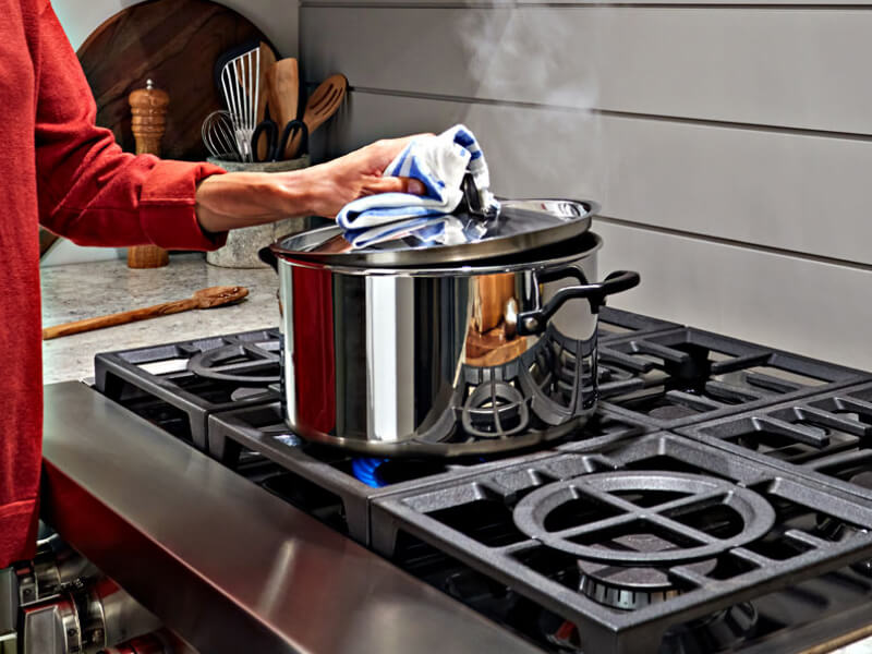 Person putting lid on a pot Person putting lid on a pot