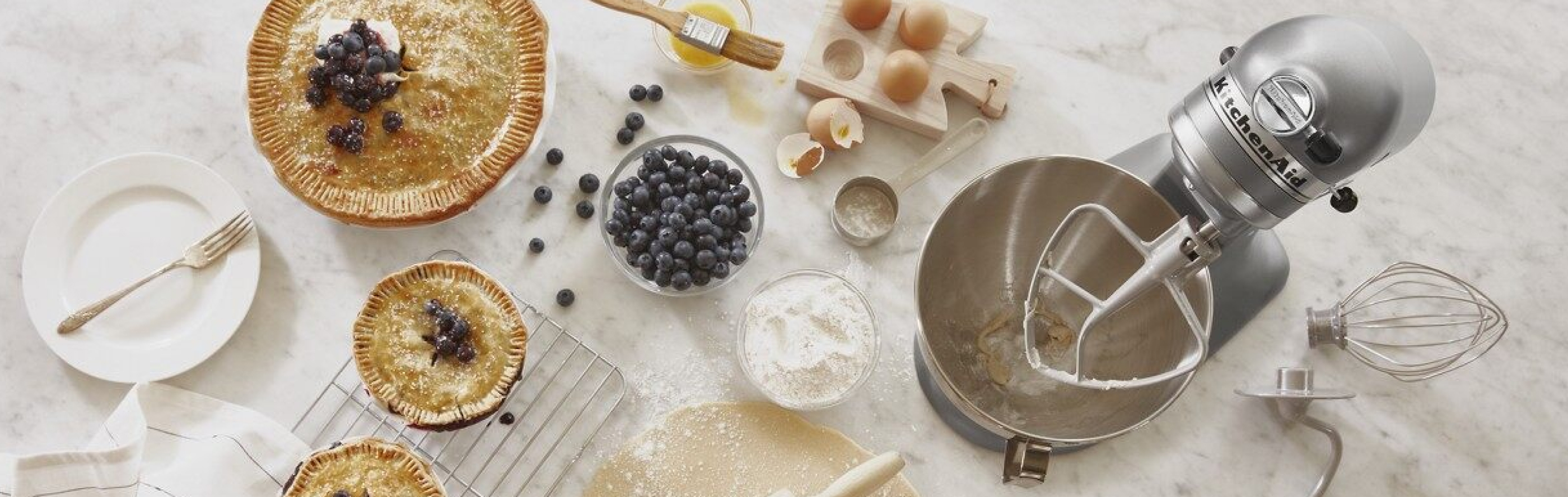 KitchenAid® stand mixer with pies and pastry ingredients