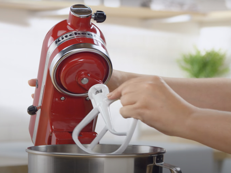 Maker attaching flat beater accessory to red KitchenAid® stand mixer