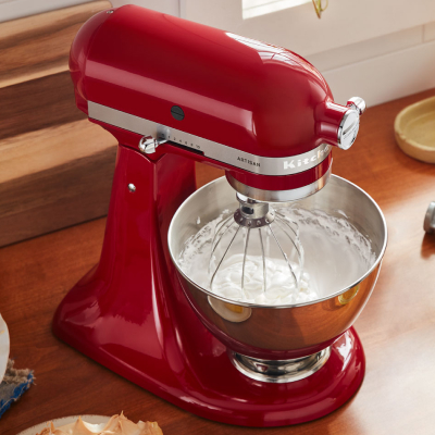 Red KitchenAid® stand mixer with stainless steel bowl and wire whisk attachment