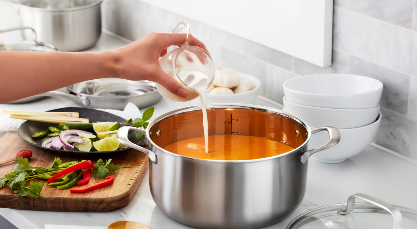 Person adding cream to a pot Person adding cream to a pot