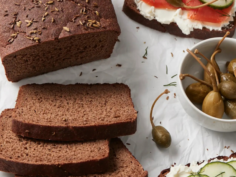 Pumpernickel loaf next to a bowl of olives