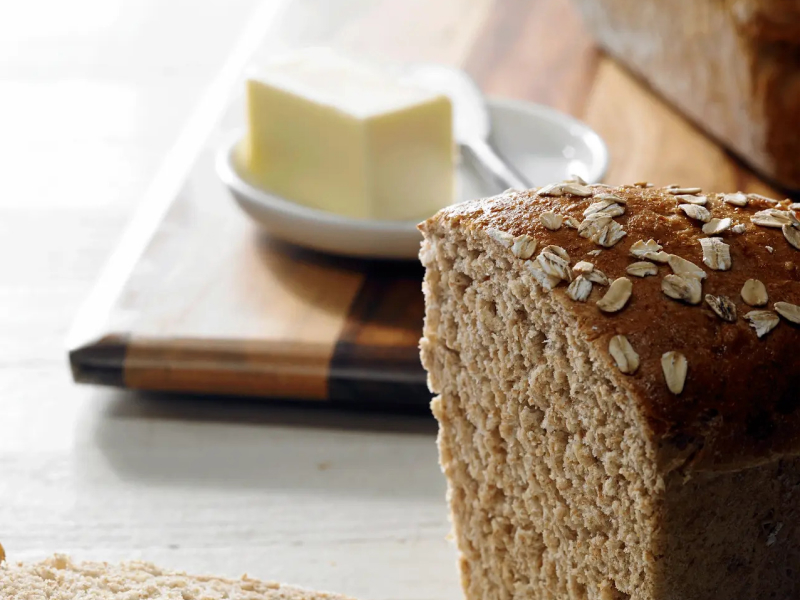 Honey wheat bread next to a stick of butter