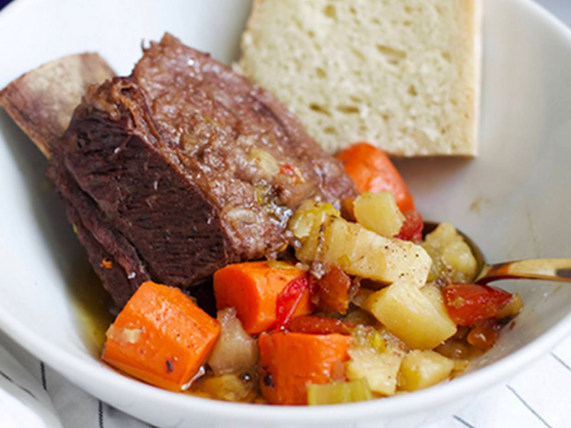 Short ribs with vegetables on plate with bread Short ribs with vegetables on plate with bread