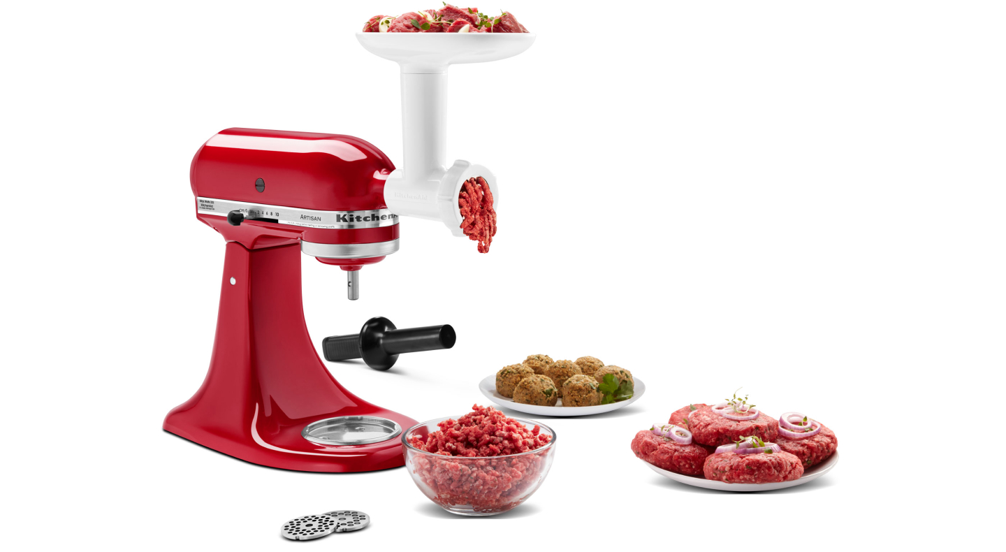 KitchenAid® stand mixer and meat grinder attachment grinding meat into bowl with plate of short rib patties and meatballs KitchenAid® stand mixer and meat grinder attachment grinding meat into bowl with plate of short rib patties and meatballs