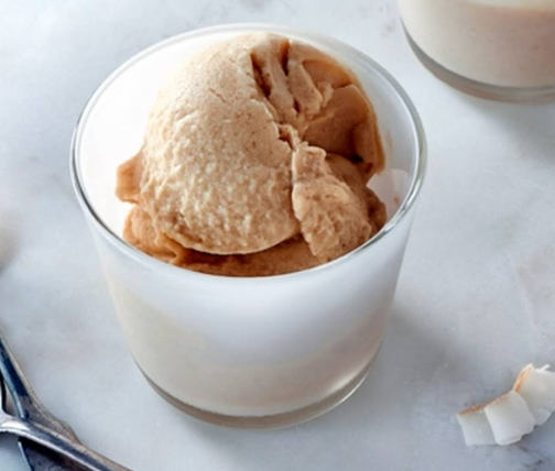 Scoop of Pineapple Coconut Ice Cream in clear glass bowl