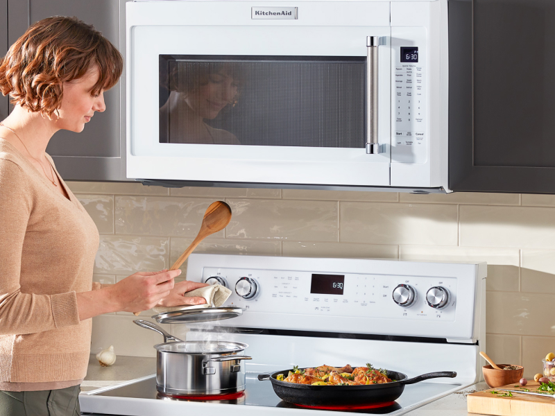 Woman cooking on a KitchenAid range Woman cooking on a KitchenAid range