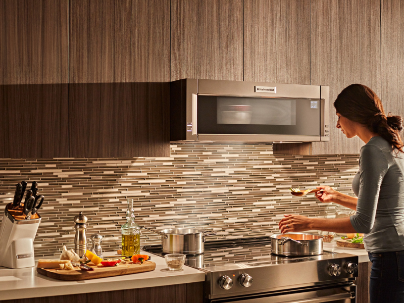 Woman cooking on a KitchenAid® electric range Woman cooking on a KitchenAid® electric range