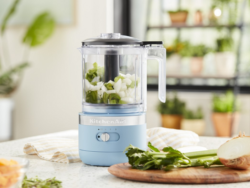 A KitchenAid® food processor filled with celery and onions A KitchenAid® food processor filled with celery and onions