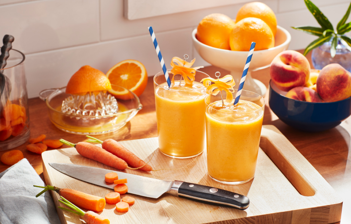 Orange smoothies in a glass on a cutting board Orange smoothies in a glass on a cutting board