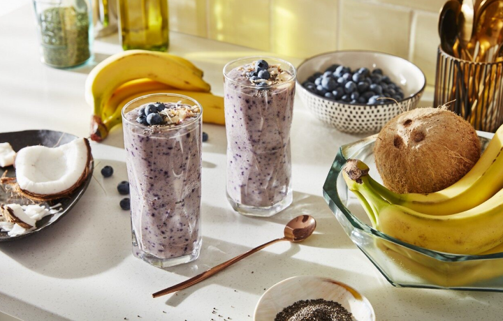 Two smoothies on a counter surrounded by ingredients Two smoothies on a counter surrounded by ingredients