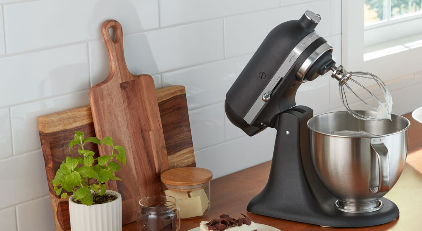 A black KitchenAid® stand mixer and various kitchen items on a countertop  A black KitchenAid® stand mixer and various kitchen items on a countertop