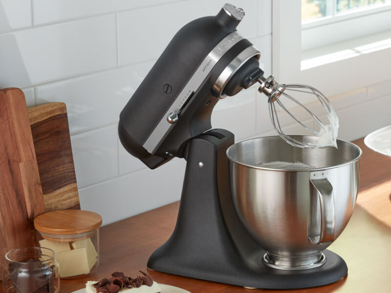A black KitchenAid® stand mixer and various kitchen items on a countertop  A black KitchenAid® stand mixer and various kitchen items on a countertop