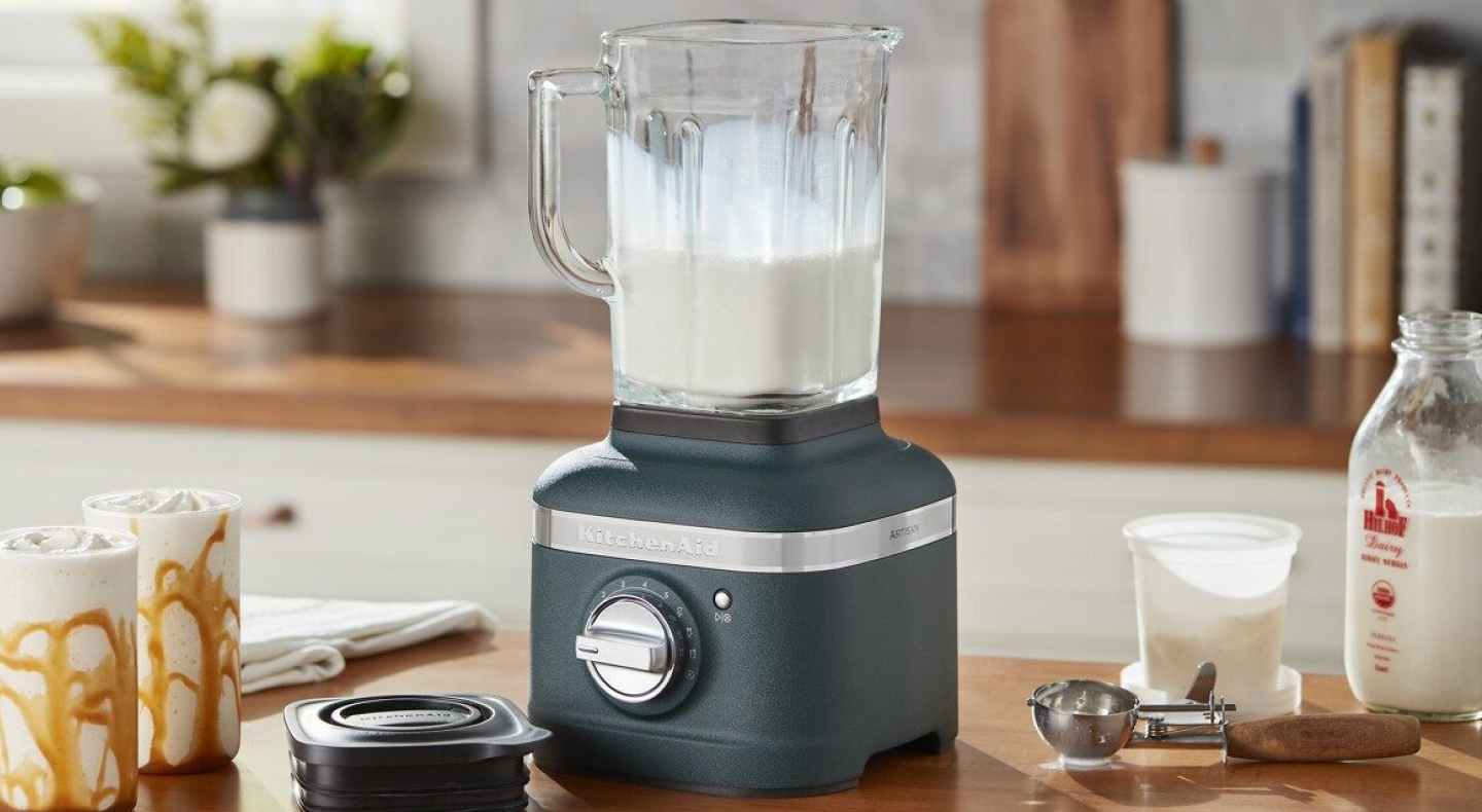 Black KitchenAid® blender filled with milk on countertop with top removed Black KitchenAid® blender filled with milk on countertop with top removed