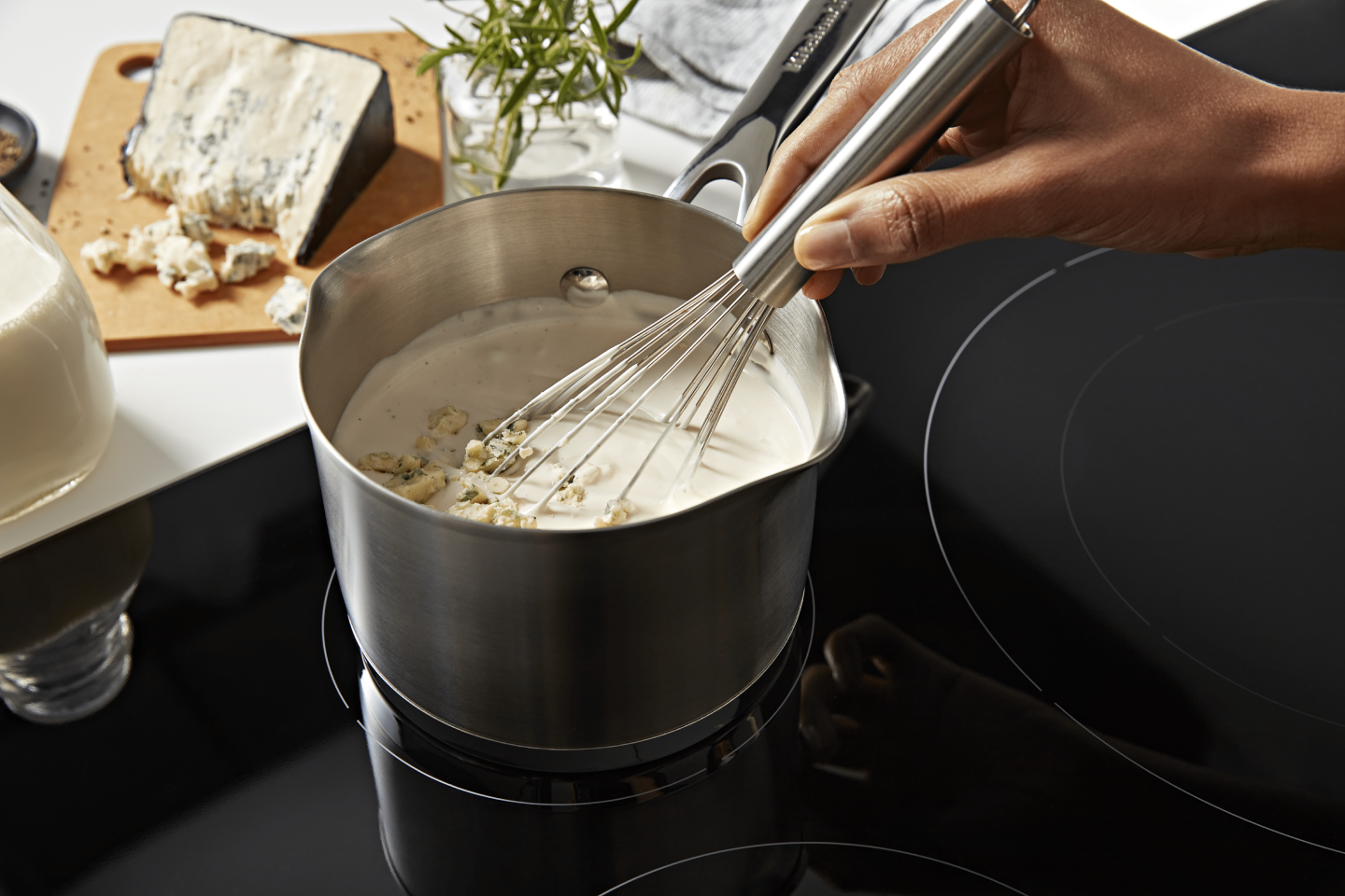 A person whisking a pot of vegan queso. A person whisking a pot of vegan queso.