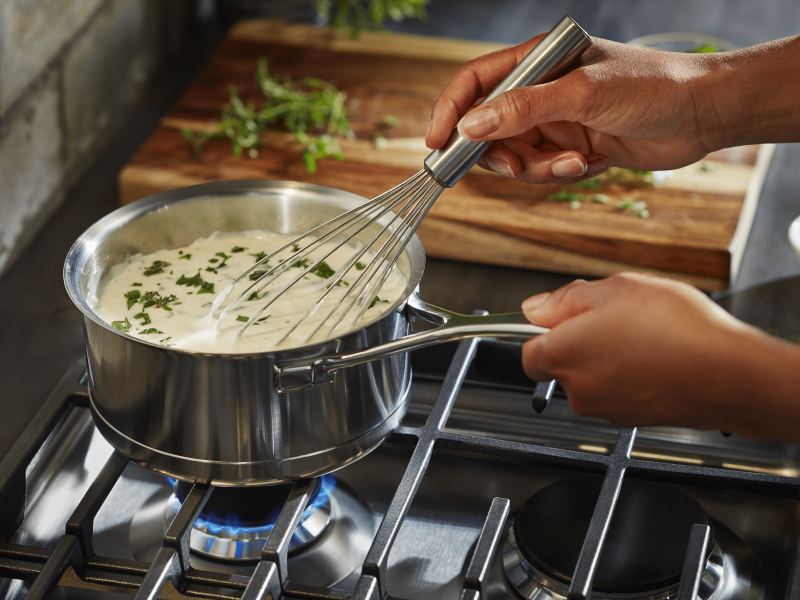 A pot of vegan queso simmering on the stove. A pot of vegan queso simmering on the stove.